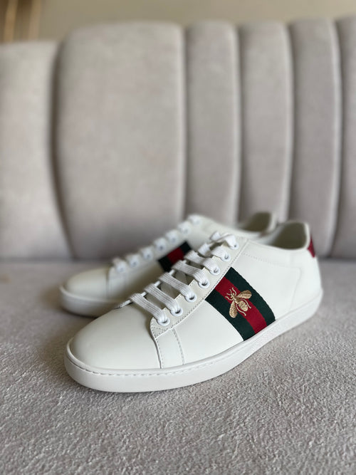 tênis Gucci Ace de couro branco com a faixa Web verde e vermelha e bordado de abelha dourada.