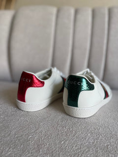 tênis Gucci Ace de couro branco com a faixa Web verde e vermelha e bordado de abelha dourada.