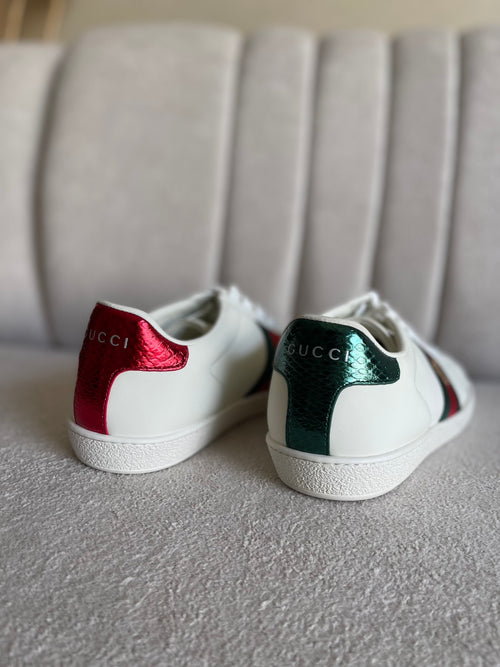 tênis Gucci Ace de couro branco com a faixa Web verde e vermelha e bordado de abelha dourada.